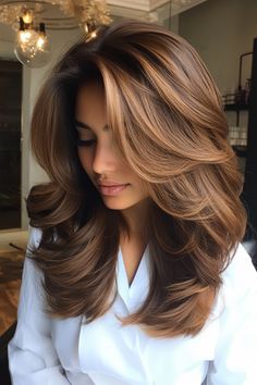 The rich brown tones enhance the depth of the cut, creating a natural, voluminous look. A brownish layered haircut features soft, cascading layers that add texture and dimension. Long Layers With Volume, Voluminous Mid Length Hair, Voluminous Haircut Medium, Brownish Hair Color, Middle Eastern Hair, Layered Blowout, Blonde Hair Trends, Long Lob, Cascading Layers