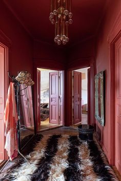 a room with red walls and an animal print rug on the floor next to it