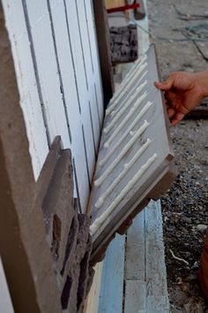 a person is holding something in front of a building that's being built into the ground