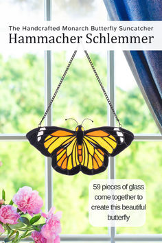 the handcrafted monarch butterfly suncather is hanging on a window sill