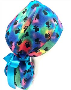 a tie dye hat with paw prints on it and a blue ribbon tied around the top