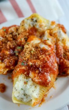 stuffed shells on a white plate with sauce and parmesan cheese in the middle