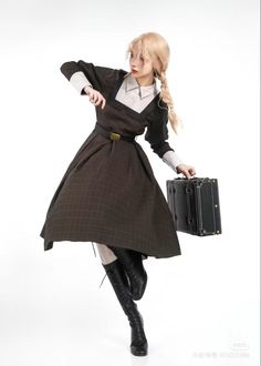 a woman dressed in an old fashioned dress and holding a suitcase while posing for the camera