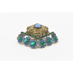 This is part of Chairish’s Costume Jewelry assortment.  This stunning vintage hallmarked Hattie Carnegie pin/ brooch can be angled or placed straight on. The gilt metal filigree work is surrounded by blue and green glass stones. Signed Hattie Carnegie on the back. This is a rare brooch and we have the matching dangle earrings to it that we think must be purchased together. Both of these pieces have been in our archives now for over 35 years.From the 60's. The combination of colors are beautiful. Ornate Blue Brooch For Formal Occasions, Ornate Blue Brooches For Wedding, Ornate Blue Wedding Brooches, Hattie Carnegie, Pin Brooch, Green Glass, Blue Glass, Costume Jewelry, Hallmark