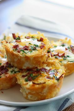 two small quiches on a white plate with avocado and blue utensils