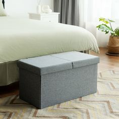 a bedroom with a bed and a storage box on the floor in front of it