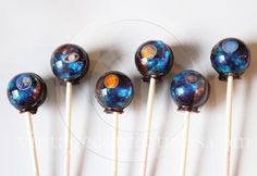 six chocolate lollipops with galaxy designs on them