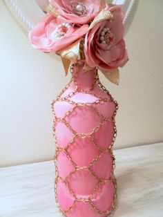 a pink vase filled with flowers on top of a table