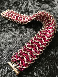 This lovely cuff bracelet is handcrafted, ring by ring, using Elf weave. The cuff comprises of two connected strands of Elf weave chain.  It's made with bright aluminium, in beautiful sparkling silver, and Rad Pink (a dark, hot-pink colour) anodized aluminium rings. The ring size and wire gauge makes it quite chunky.  This cuff bracelet is 2.5cm wide, 0.7cm high and 20.5cm in length, including the plated slide clasp.  Wear it when you're going somewhere special, or as an every day luxury - you d Wire Gauge, Small Skull, Chainmaille Bracelet, Woven Chain, Pink Colour, Bracelet Clasps, Pink Bracelet, Wrapped Pendant, Chain Choker