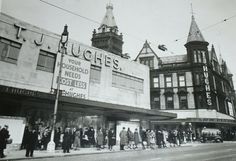 an old black and white photo of people standing in front of a theater