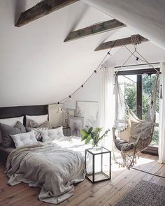 an attic bedroom decorated for christmas with hanging hammock chairs