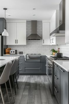 a kitchen with gray cabinets and white counter tops