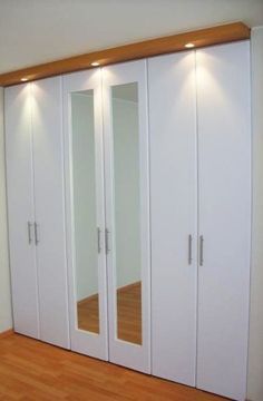 an empty room with white closets and wood floors