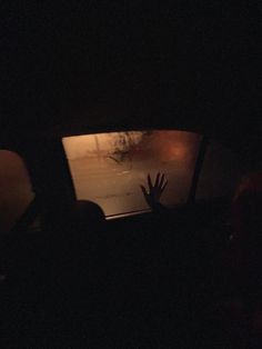 a person's hand is in the window of a car at night with fog