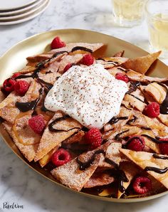 dessert nachos with whipped cream and raspberries on a gold platter