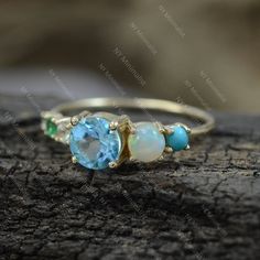 This ring is made with Genuine Sleeping Beauty Arizona Turquoise/ Zambia Emerald/ Blue Topaz & Ethiopian Opal Gemstone & SI Clarity G-H Color Diamond and 14K solid yellow gold * SKU: SGR01148 * Made to Order * Gold Purity: 14K Solid Yellow Gold (stamped) * Custom Gold Color: Rose Gold, Yellow Gold, White Gold * Custom Gold Purity: 9K/14K/18K (Charges Apply) * Diamond 100% Genuine Diamond * Diamond weight: 0.03 ct * Diamond Color: G-H * Diamond Clarity: SI1- SI2 * Diamond Cut: Brilliant C Blue May Birthstone Rings, Blue Aquamarine Multi-stone Jewelry, Blue Multi-stone Aquamarine Jewelry, Blue Three Stone Birthstone Ring, Turquoise Aquamarine Birthstone Ring, Turquoise Birthstone Ring With Accent Stones, Turquoise Multi-stone Round Opal Ring, Turquoise Birthstone Ring With Accent Stones For Anniversary, Blue Emerald Ring For May Birthstone