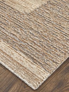 an area rug with brown and white stripes on the top, in front of a wooden floor