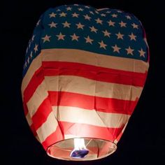 a hot air balloon with the american flag on it's side, lit up at night