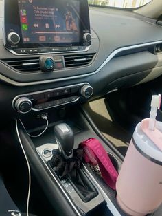 the interior of a car with an electronic device and cup holder in it, along with other accessories