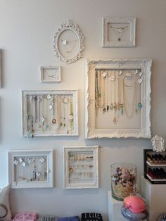 there are many different frames on the wall with necklaces and jewelry hanging from them