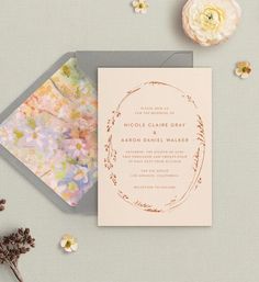 the wedding stationery is laid out next to flowers