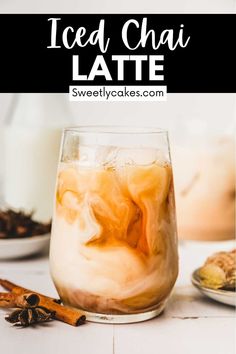 iced chai latte in a glass with ice and cinnamon sticks on the side