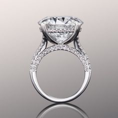 a white gold ring with an oval cut diamond surrounded by pave set round brilliant diamonds