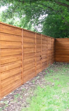 a wooden fence in the middle of a grassy area