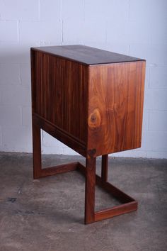 a small wooden cabinet sitting on top of a cement floor