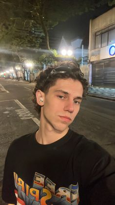 a young man is standing on the street at night