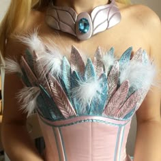 a woman wearing a corset with feathers on it's chest and collar