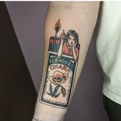 a person with a tattoo on their arm holding a lit candle in front of him