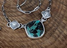 This necklace features a stunning and rare piece of Blue Diamond Turquoise that’s full of a deep teal and bold, painterly black markings - it definitely packs a punch! The stone is adorned with one of my favorite elements, hand stamped puffy diamonds. The silver is oxidized to bring out all the fine details and depth and is topped off with a brushed finish. The pendant hangs on a 17’’ sterling silver paperclip chain with a handmade clasp. The chain has been darkened to match the patina on the pe Turquoise Chrysocolla Necklace With Patina, Deep Teal, Blue Diamond, Paper Clip, Hand Stamped, Diamond Necklace, Patina, My Favorite, Diamonds