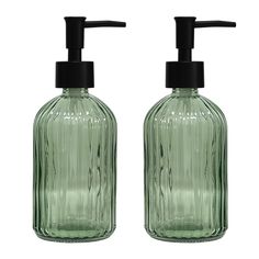 two green glass soap dispensers with black plastic caps on each one side