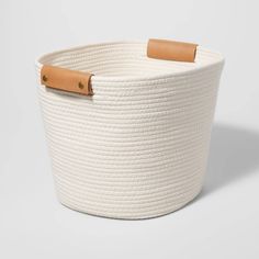 a large white basket with leather handles