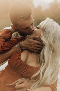 a man and woman kissing each other on the beach