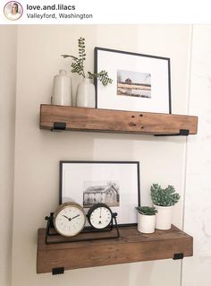 two wooden shelves with pictures, clocks and plants on them in the corner of a room