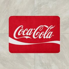 the coca - cola logo is shown in red and white on a light gray background