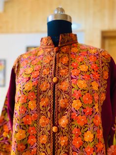 Embroidered Coat , Kashmiri Jacket Description Allow yourself to be lost in the lush flora of Kashmir's enchanted forests every time you wear the Long Kashmiri Jacket. This Kashmiri embroidered jacket is crafted in 100% pure wool/ Pure Raw Silk and . This festival season, you'll be warmed by not just the luxurious fabric but also by our artisans' love for their craft. ● 100% Pure wool / Pure raw Silk ● Crafted in Kashmir ● Traditionally embroidered by our artisans ● Can Also Be Customised In col Traditional Nehru Jacket With Floral Print, Fall Floral Print Outerwear With Stand Collar, Traditional Embroidered Outerwear For Fall, Traditional Embroidered Fall Outerwear, Long Sleeve Outerwear With Floral Embroidery For Fall, Fall Outerwear With Multicolor Embroidery And Floral Print, Fall Floral Print Outerwear With Multicolor Embroidery, Fall Floral Print Multicolor Embroidered Outerwear, Fall Multicolor Embroidered Floral Outerwear