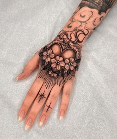 a woman's hand with tattoos and flowers on it