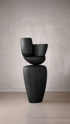 three black chairs stacked on top of each other in front of a wall and floor