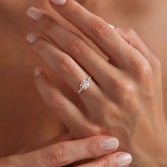 a woman's hand with a diamond ring on it