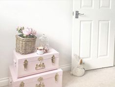 two pink suitcases are stacked on top of each other in front of a door