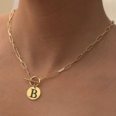 Define your style with our Cleo Paperclip Initial Necklace, a sophisticated accessory that brings together elegance and personalization. This 14k gold necklace allows you to carry your initials or those of a loved one close to your heart. Its versatile design offers you the choice of wearing it alone or pairing it with other pieces for a layered look. It's a perfect gift for yourself or someone special in your life. Initial Disc: Available in 14k Plated or Stainless Steel, engraved with 1 to 3 i Elegant Personalized Yellow Gold Chain Necklace, Gold Minimalist Initial Necklace With Paperclip Chain, Minimalist Gold Initial Necklace With Paperclip Chain, Elegant Everyday Initial Necklace With Paperclip Chain, Elegant Personalized Link Necklaces, Elegant Oval Link Charm Necklace For Gifts, Elegant Paperclip Charm Necklaces For Everyday, Elegant Initial Pendant Necklace With Paperclip Chain, Elegant Gold-tone Charm Necklace With Initial Pendant