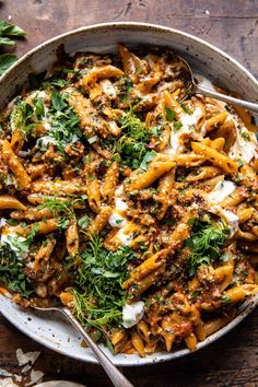 a bowl filled with pasta and sauce on top of a wooden table