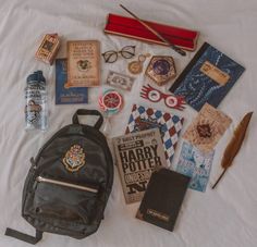 the contents of a harry potter backpack laid out on a bed