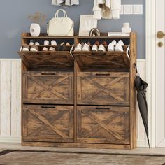 a wooden cabinet with shoes on it in front of a blue wall and white door