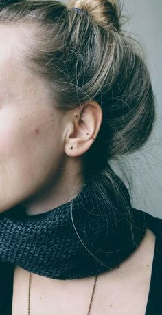 a close up of a person wearing a black shirt and a necklace on her neck