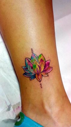 a woman's foot with a colorful flower tattoo on the side of her leg