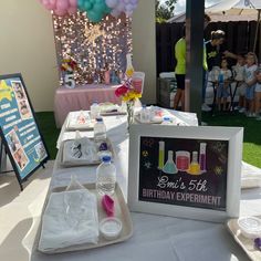 a birthday party with balloons and decorations on the table, including an ice cream parlor sign